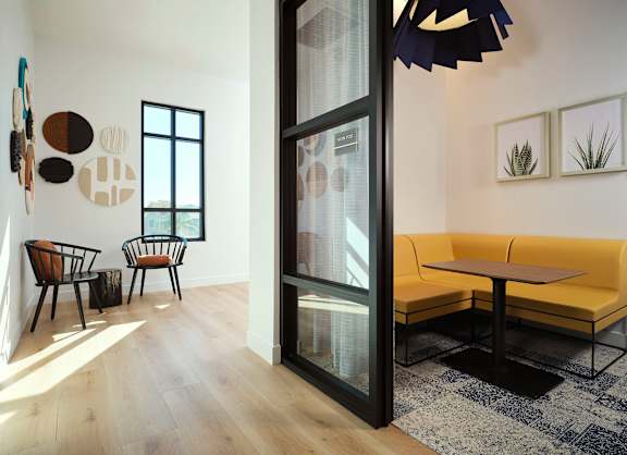 A modern living room with a yellow sofa and a glass door.