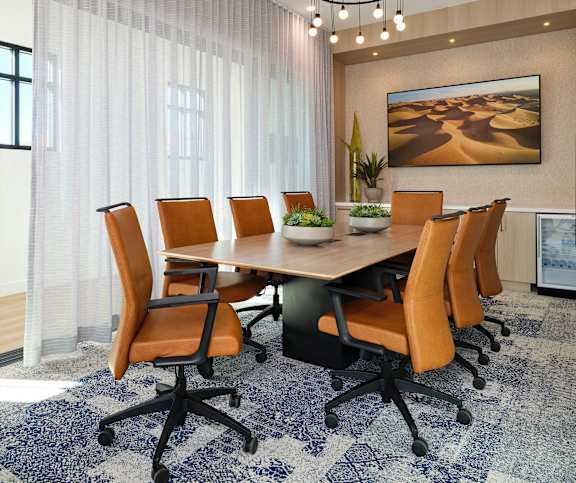 A conference room with a large table surrounded by chairs.