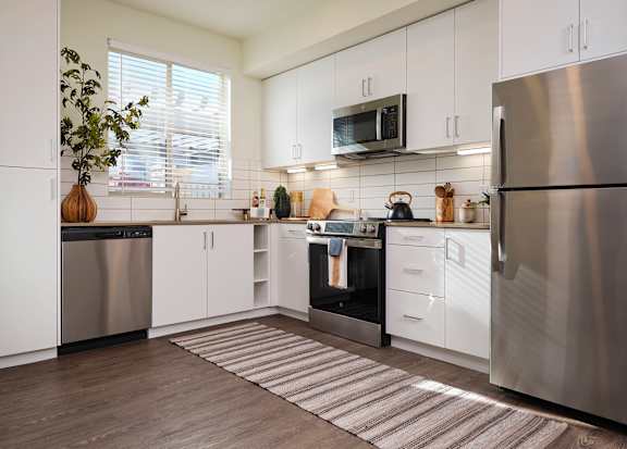 A modern kitchen with stainless steel appliances and white cabinets.