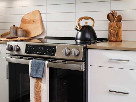 A modern kitchen with a stove top oven and a kettle on it.
