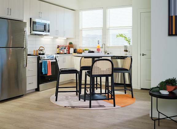 A kitchen with a table and chairs in the middle of the room.