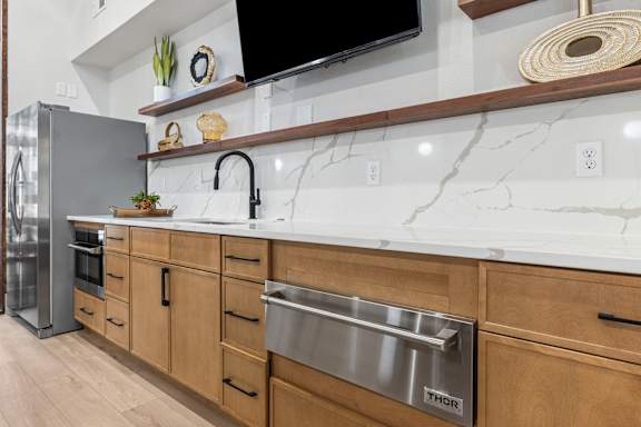 A kitchen with a marble countertop and wooden cabinets.