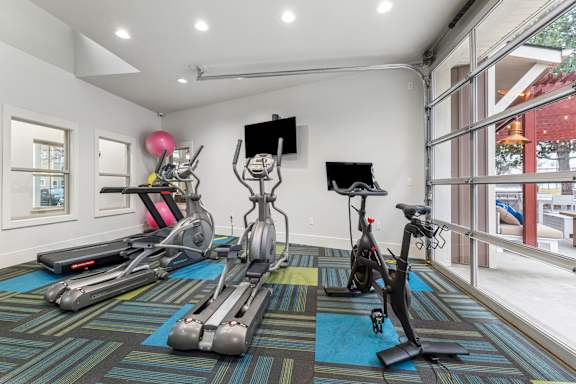 A room with exercise equipment and a TV.
