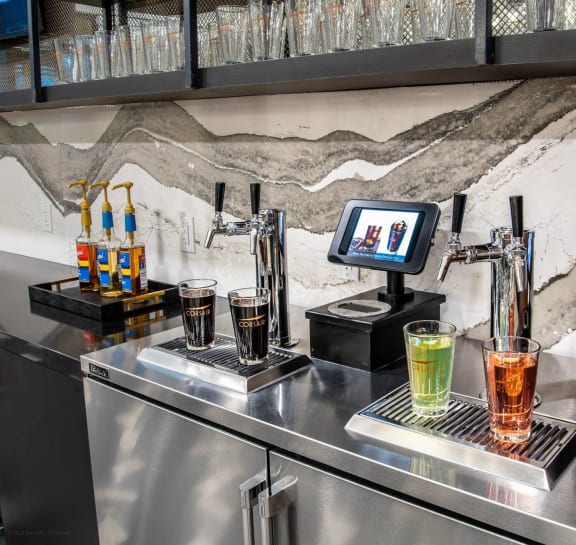 a bar with drinks on top of a stainless steel counter