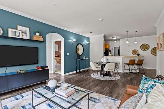 A living room with a blue wall and a black television.