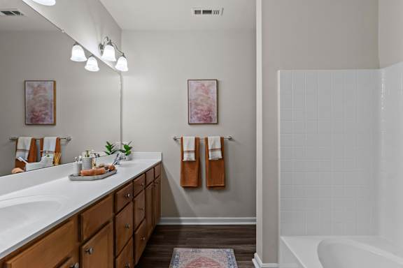 A bathroom with a white tub and a white sink.