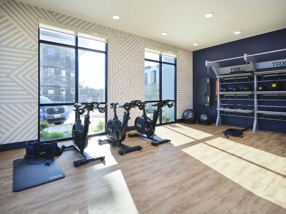a home gym with exercise equipment and windows