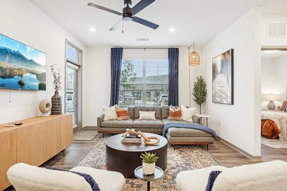 A living room with a couch, a coffee table, and a painting on the wall.