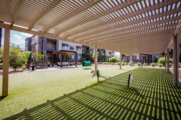 A long wooden pergola over a grassy area.
