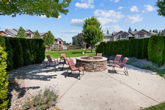 an outdoor patio with a fire pit and chairs
