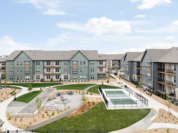 A large apartment complex with a playground in the courtyard.