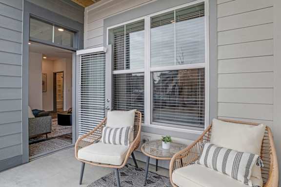 A patio with two chairs and a table.