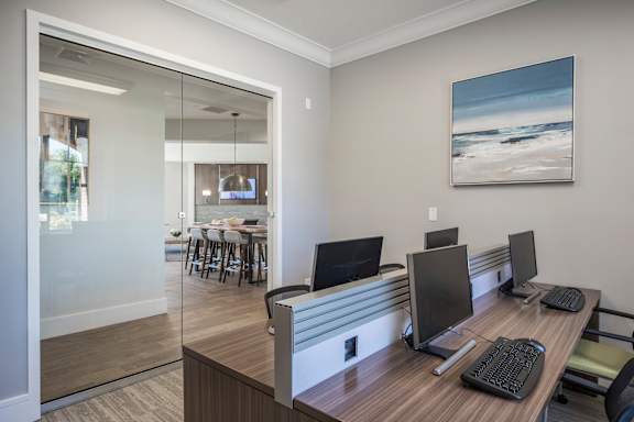 A modern office with a view of the beach through the glass wall.