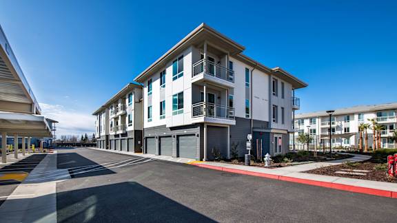 A modern apartment building with a clear blue sky above.