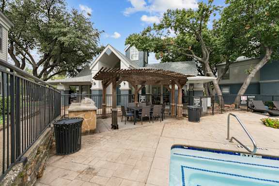 A pool area with a gazebo and a fence.