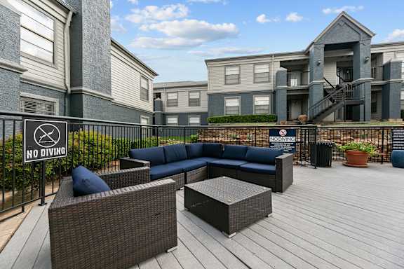 A patio with a "NO DIVING" sign and a couch.