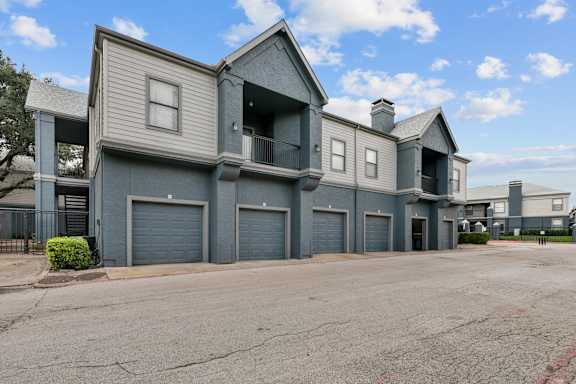 A large grey building with multiple garage doors and balconies.