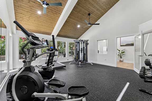 Home gym with elliptical and weight equipment at Knoll Crest Apartments, San Antonio, Texas