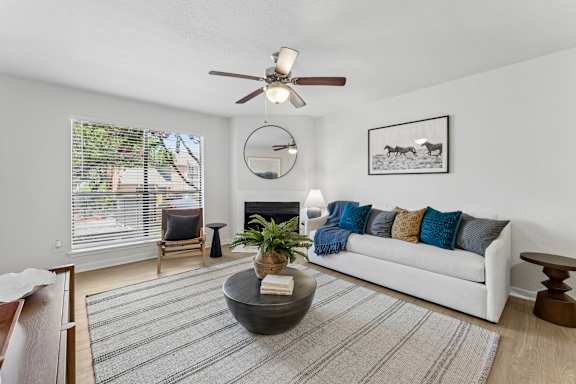 Living room with white sofa and round coffee table at Knoll Crest Apartments, San Antonio