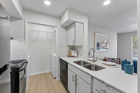 Kitchen with stainless steel sink and white countertops at Knoll Crest Apartments, Texas