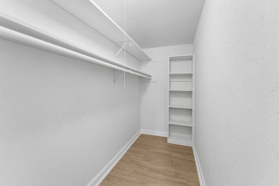 Walk-in closet with built in shelving at Knoll Crest Apartments, San Antonio, TX 78240