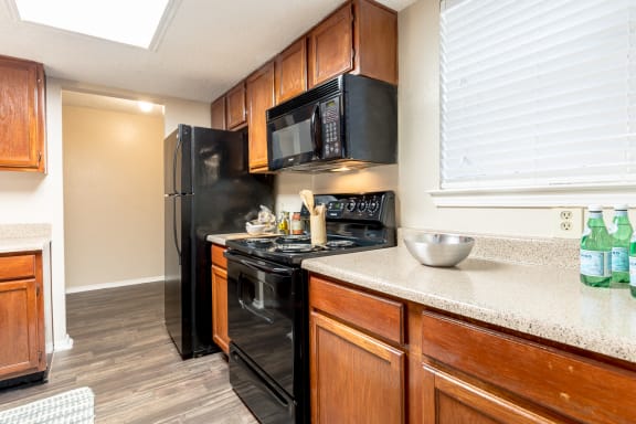 Cabinets of wood and appliances at Amberly Village Townhomes, Garland, TX, 75040