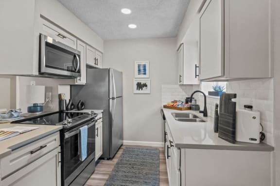 a kitchen with stainless steel appliances and white cabinets&#xA0;at Maxwell Townhomes, Texas