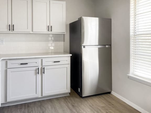 a kitchen with white cabinets and a stainless steel refrigerator  at Sunset Heights, Texas, 78209