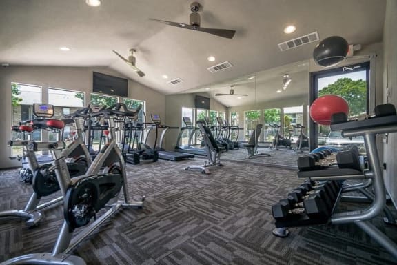 a gym with a lot of exercise equipment and windows at Rock 35, Round Rock, Texas
