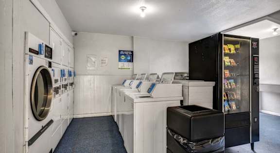 A laundromat with a washer and dryer on the left and a vending machine on the right.