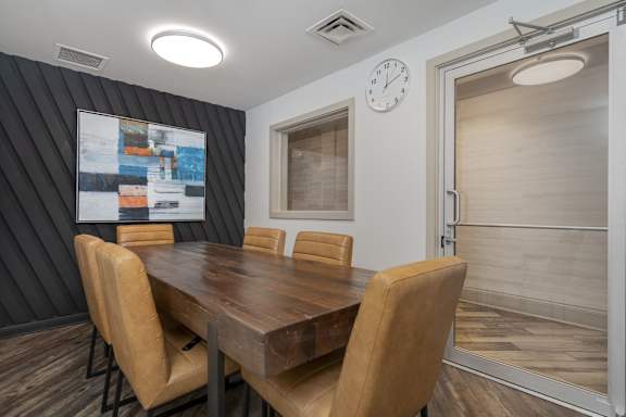 A conference room with a wooden table and chairs.
