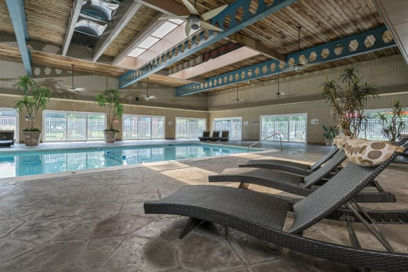 a swimming pool with two lounge chairs