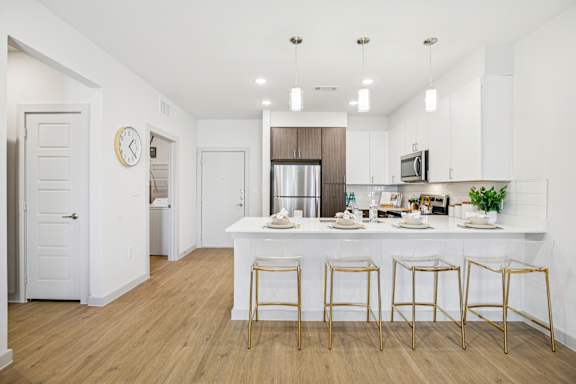 A kitchen with a bar area and four stools. at ThreeTwenty at the Vybe Apartments, Texas, 78640