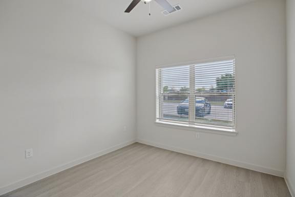 Empty bedroom with window blinds and light flooring 1 at Cantarra Apartments, Manor, TX 78653
