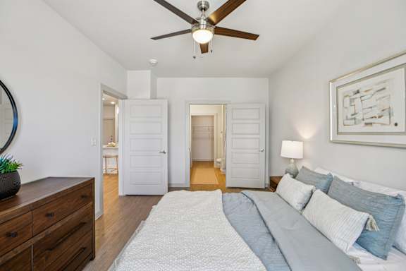 A bedroom with a bed, dresser, and mirror at ThreeTwenty at the Vybe Apartments, Texas