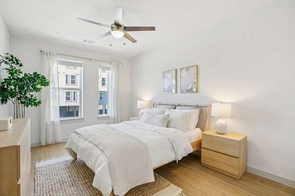 A bedroom with a large bed and a ceiling fan. at ThreeTwenty at the Vybe Apartments, Kyle