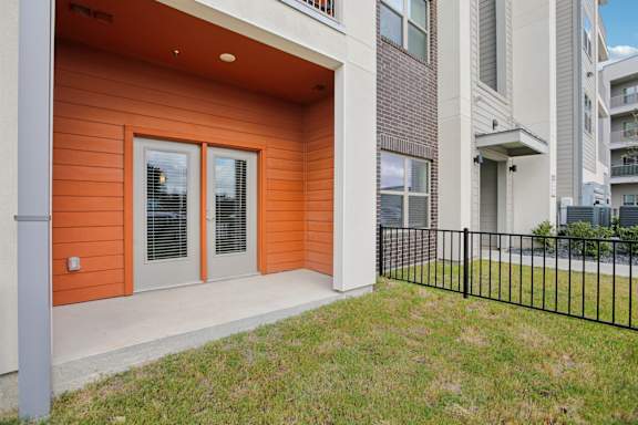 Private patio with french doors and metal railing 1 at Cantarra Apartments, Texas