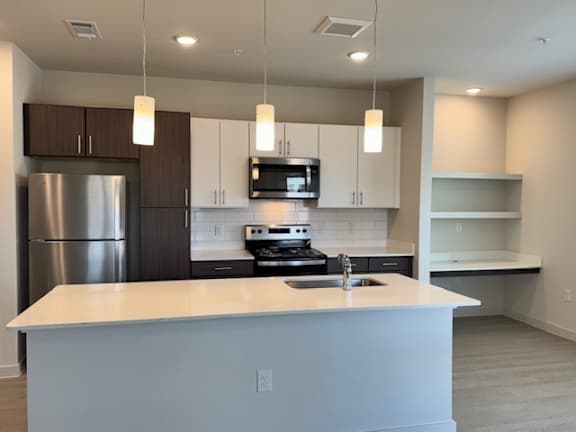 Modern kitchen with white countertops and open shelving at Cantarra Apartments, Texas