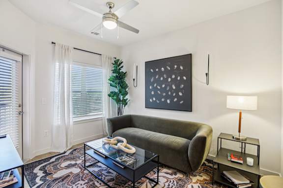 Living room with green sofa at Matador Apartments, Austin, TX