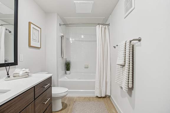 A white bathroom with a toilet, sink, and bathtub. at ThreeTwenty at the Vybe Apartments, Texas, 78640