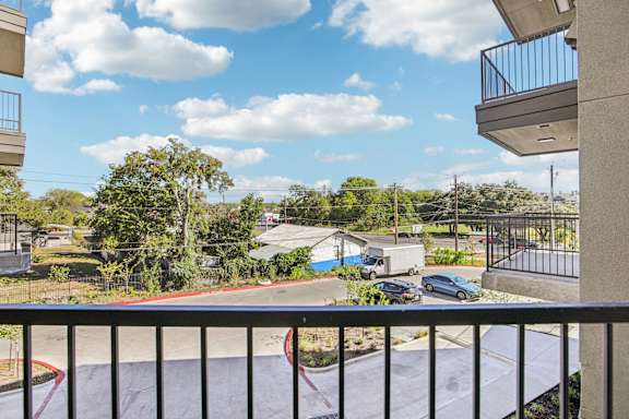 Balcony view overlooking parking area and trees at Matador Apartments, Texas, 78745