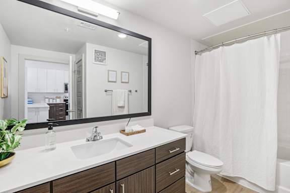 A bathroom with a white sink and toilet. at ThreeTwenty at the Vybe Apartments, Kyle, TX, 78640
