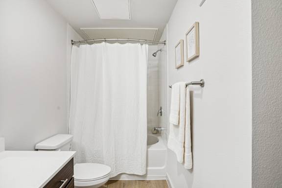 A white bathroom with a toilet, sink, and shower at ThreeTwenty at the Vybe Apartments, Texas, 78640