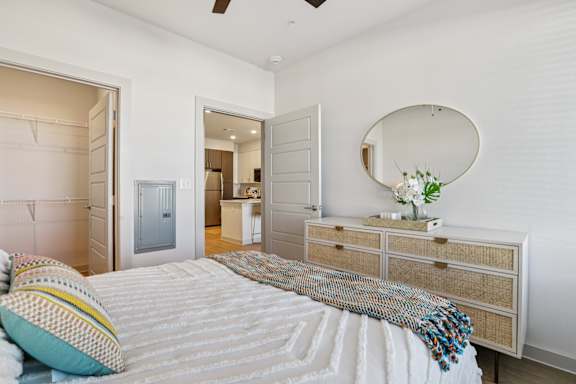 A bedroom with a bed, dresser, and mirror. at ThreeTwenty at the Vybe Apartments, Texas, 78640