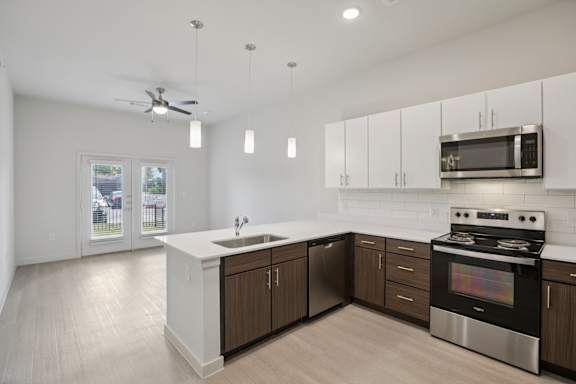 Kitchen with white countertops and stainless appliances 1 at Cantarra Apartments, Manor, Texas
