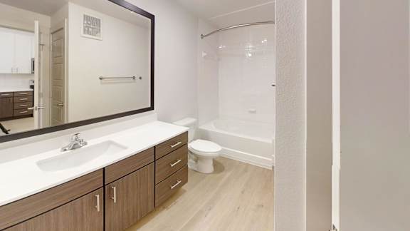 A bathroom with a sink, mirror, and toilet.