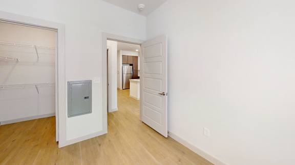 A white room with a door and a small window.