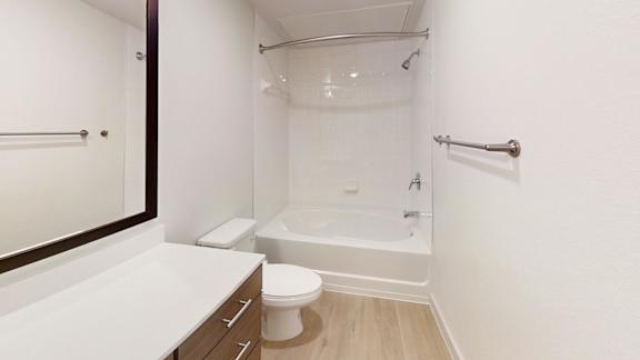A white bathroom with a toilet, sink, and bathtub.
