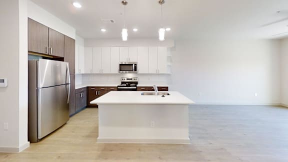 A modern kitchen with stainless steel appliances and a central island.