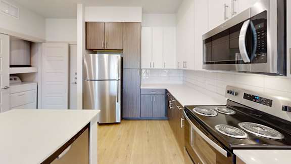 A modern kitchen with stainless steel appliances and wooden cabinets.